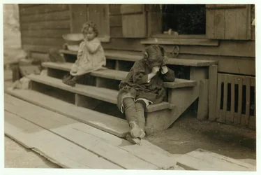 Die 5-jährige Olga Schubert begann gegen 5:00 Uhr morgens ihrer Mutter in der Biloxi Canning Factory, Mississippi, beim Garnelenpulen zu helfen. Sie war erschöpft und weigerte sich, fotografiert zu werden, 1911